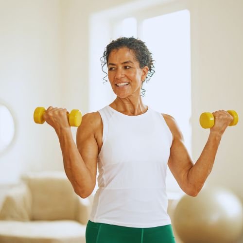 Woman strength training with dumbbells at home